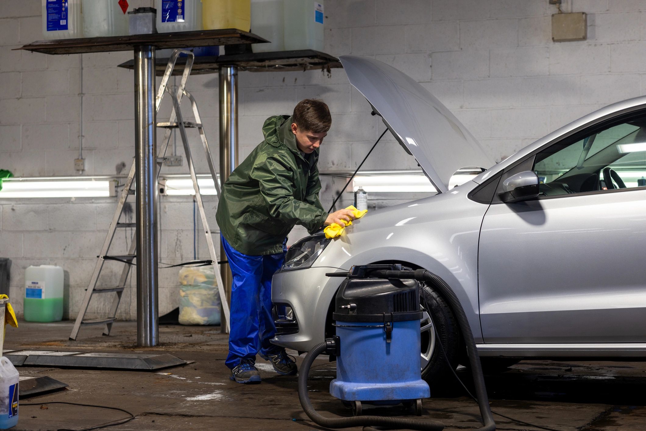 Car being cleaned in a professional detailing bay